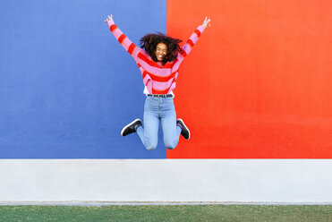 Happy young woman jumping in the air - KIJF02121