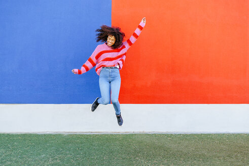 Happy young woman jumping in the air - KIJF02122