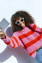 Porträt einer jungen Frau mit Sonnenbrille, die ein Selfie mit ihrem Mobiltelefon macht - KIJF02130