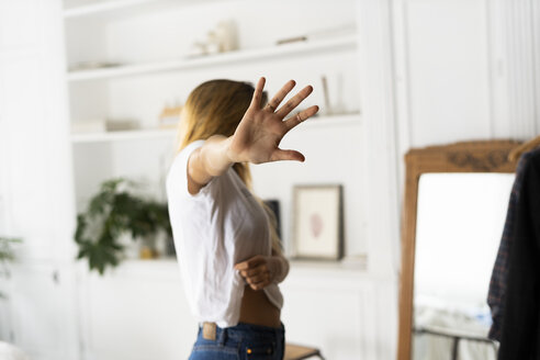 Abuse and violence against women, woman raising hand at home - ERRF00059