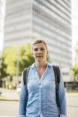 Porträt einer Frau mit Rucksack in der Stadt, lizenzfreies Stockfoto