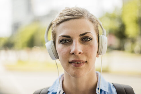 Porträt einer selbstbewussten Frau mit Kopfhörern - MOEF01561