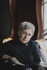 Porträt einer älteren Frau auf einer Couch sitzend - KMKF00621