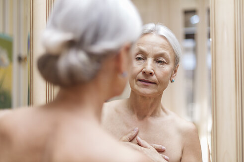 Ältere Frau schaut ihr Spiegelbild an - VGF00112