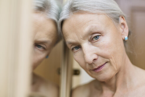 Porträt einer älteren Frau, die sich an einen Spiegel lehnt - VGF00113