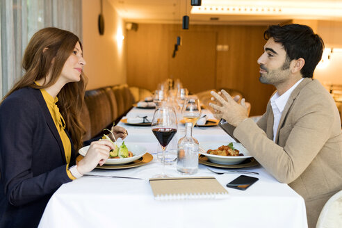 Lächelnder Mann und lächelnde Frau beim Essen in einem Restaurant - VABF01653