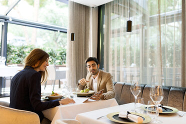 Mann und Frau teilen sich ein Tablet in einem Restaurant - VABF01660