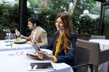 Mann beim Essen und Frau beim Telefonieren in einem Restaurant - VABF01665