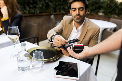 Mann zahlt mit Kreditkarte in einem Restaurant - VABF01673