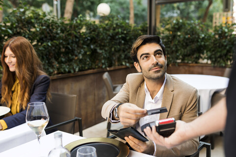 Man paying with credit card in a restaurant stock photo