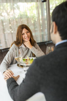 Lächelnde Frau hält Hände mit Mann in einem Restaurant - VABF01688