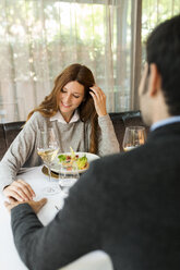 Lächelnde Frau hält Hände mit Mann in einem Restaurant - VABF01689