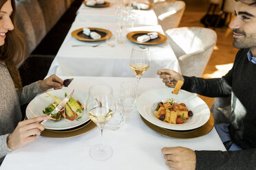 Lächelndes Paar isst Vorspeise in einem Restaurant - VABF01693