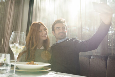 Lächelndes Paar macht ein Selfie in einem Restaurant - VABF01695