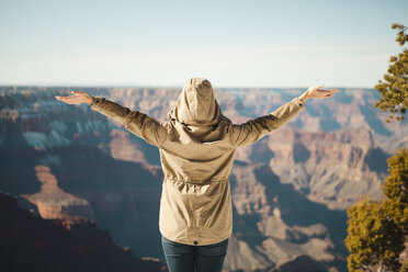 Frau mit ausgestreckten Armen im Grand Canyon National Park stehend - CAVF54104