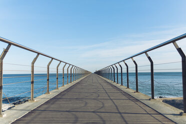 Diminishing perspective of pier over sea against sky - CAVF54146