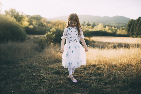 Mädchen in voller Länge im weißen Kleid beim Spielen im Park - CAVF54156