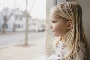 Close-up of girl sitting by window at home - CAVF54175