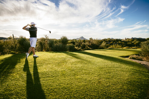 Golfer in voller Länge auf dem Feld gegen den Himmel spielend - CAVF54223