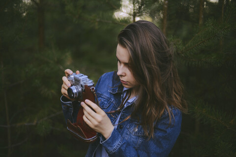 Frau fotografiert Kiefern im Wald, lizenzfreies Stockfoto