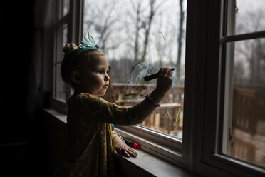 Seitenansicht eines Mädchens, das am Fenster zeichnet - CAVF54298