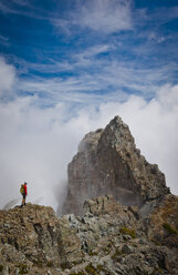 Hohe Winkel Ansicht von Wanderer stehen auf Berg inmitten von Wolken - CAVF54363