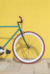 Gegen gelbe Wand geparktes Fahrrad auf dem Bürgersteig in der Stadt - CAVF54409