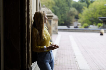 Woman leaning on wall at park - CAVF54481