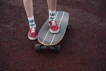 Woman's legs in socks and sneakers standing on carver skateboard - VPIF00971