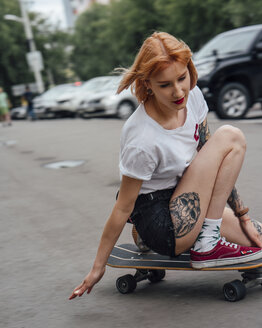 Junge Frau fährt auf einem Carver-Skateboard auf einer Straße - VPIF01002