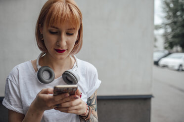 Junge Frau mit Kopfhörern und Mobiltelefon - VPIF01019