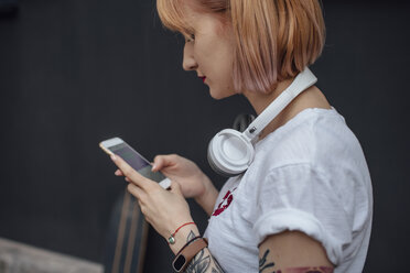 Young woman with headphones using cell phone - VPIF01020