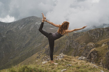 Red-haired woman doing yoga on top of a mountain, lord of the dance - AFVF01948