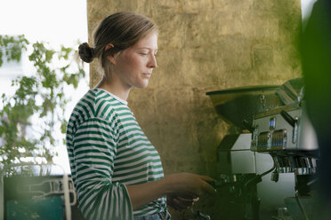 Junge Frau bereitet Kaffee in einem Café zu - KNSF05297