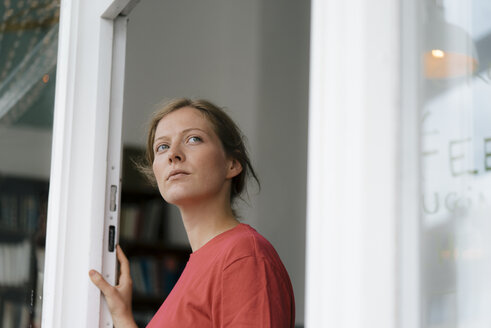 Young woman at French door in a cafe looking around - KNSF05320