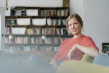 Portrait of smiling young woman sitting in a cafe - KNSF05339