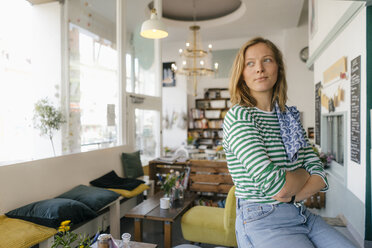 Junge Frau in einem Café mit Blick zur Seite - KNSF05349