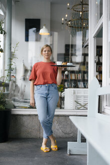 Porträt einer jungen Frau, die Kaffee und Kuchen in einem Café serviert - KNSF05364