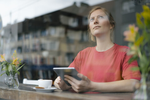 Young woman using tablet at the window in a cafe stock photo