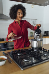 Woman standing in kitchen, preparing food - BOYF00954