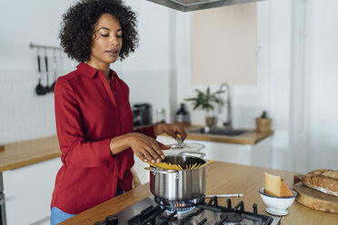 Woman standing in kitchen, preparing spaghetti - BOYF00959