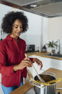 Frau steht in der Küche und bereitet Spaghetti zu - BOYF00960