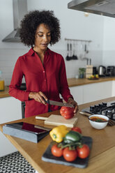 Woman standing in kitchen, chopping vegetables - BOYF00962