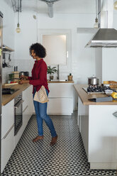 Woman standing in kitchen, preparing food - BOYF00965