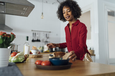 Woman standing in kitchen, slicing bread - BOYF00969