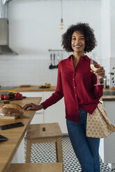 Woman standing in kitchen, drinking a glass of white wine - BOYF00984