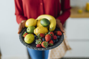 Woman holding plate with fruit - BOYF00996