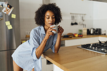 Frau steht in ihrer Küche und trinkt ihren Morgenkaffee - BOYF01068