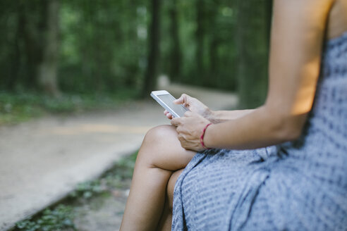 Frau benutzt Smartphone im Freien, Teilansicht - MOMF00543