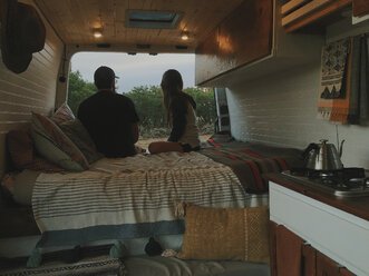 Ehepaar entspannt auf dem Bett im Wohnmobil im Wald - CAVF54622